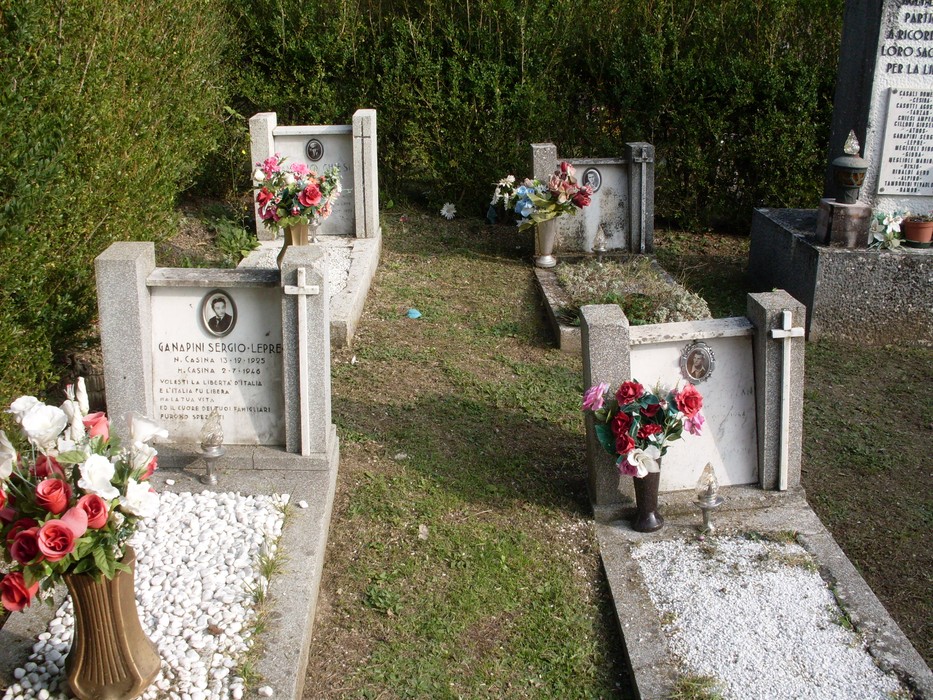 Sacrario dei partigiani con tombe decorate da fiori, commemorando i caduti della resistenza.