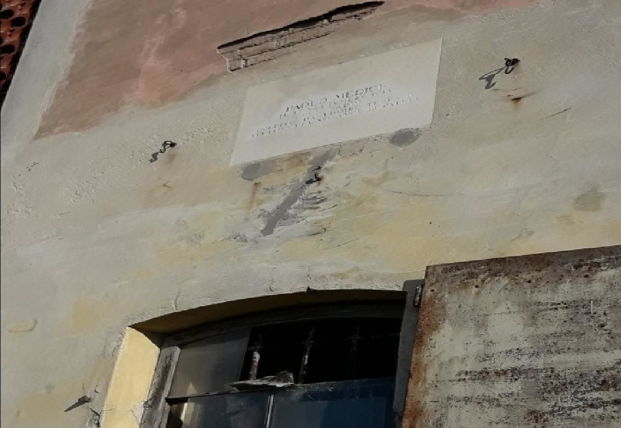 Lapide commemorativa sui Medici, affissa su un edificio storico, con pareti consumate dal tempo.