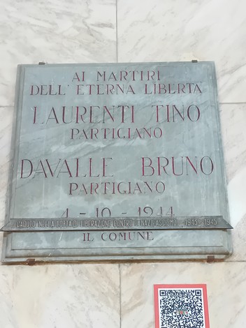 Lapide commemorativa in marmo dedicata ai partigiani Laurenti e Davalle, con iscrizione in rosso e nero.