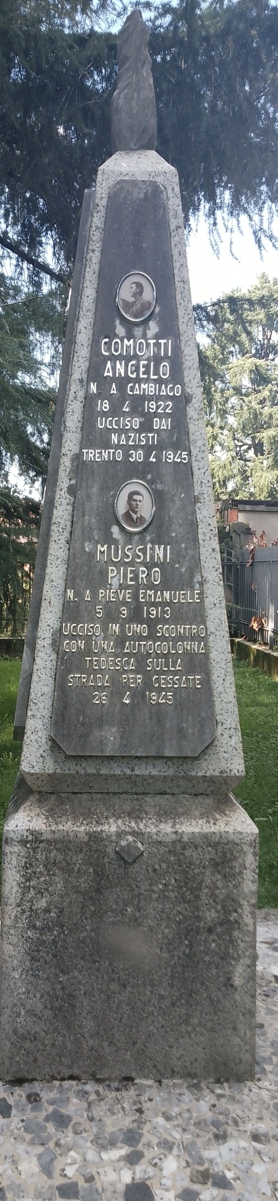 Monumento agli antifascisti con lapidi commemorative in pietra, circondato da vegetazione.