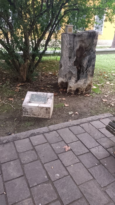 Cippo commemorativo in un giardino, circondato da vegetazione e pietre, per i colognesi deportati.