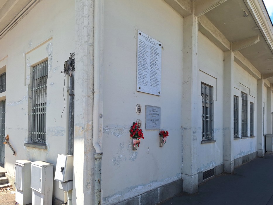 Lapide commemorativa dedicata ai caduti e partigiani di Madonna di Campagna, posizionata su una parete esterna.