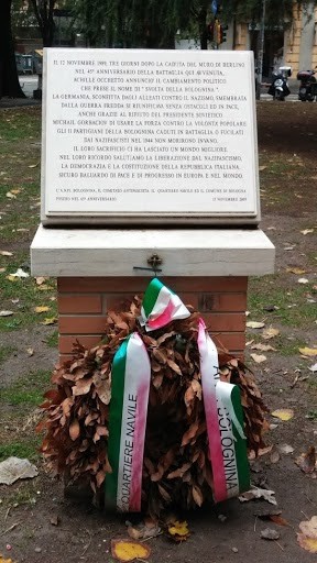 Monumento commemorativo della battaglia della Bolognina, con dedica e decorazione floreale.