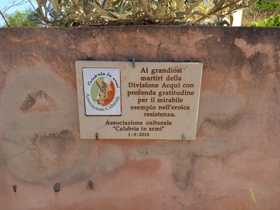 Lapide commemorativa dedicata ai martiri della Divisione Acqui, con messaggio di gratitudine per la resistenza.