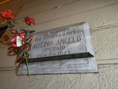 Lapide commemorativa dedicata a Autino Angelo, operaio, con roses decorative.