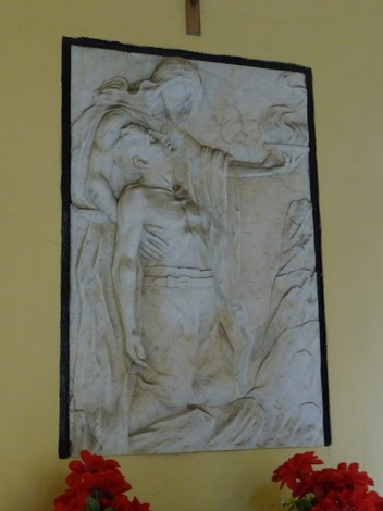 Cappella dedicata ai partigiani caduti, con scultura che rappresenta un momento di sacrificio e memoria.