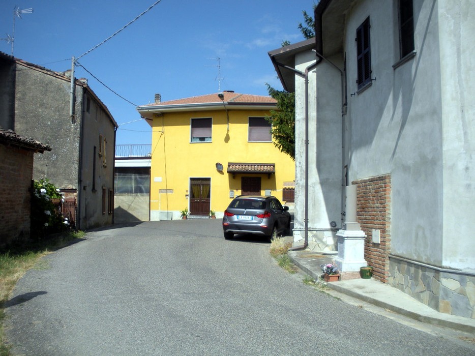 Monumento ai Vedaschi: scorcio di un vicolo con edifici e un'auto in un contesto storico e caratteristico.