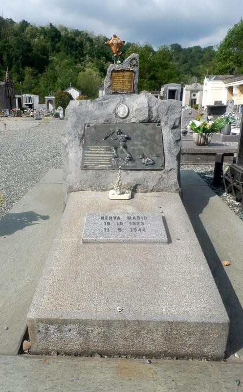Sepolcro di Nerva, monumento commemorativo con rilievi e iscrizioni, immerso in un contesto naturale.