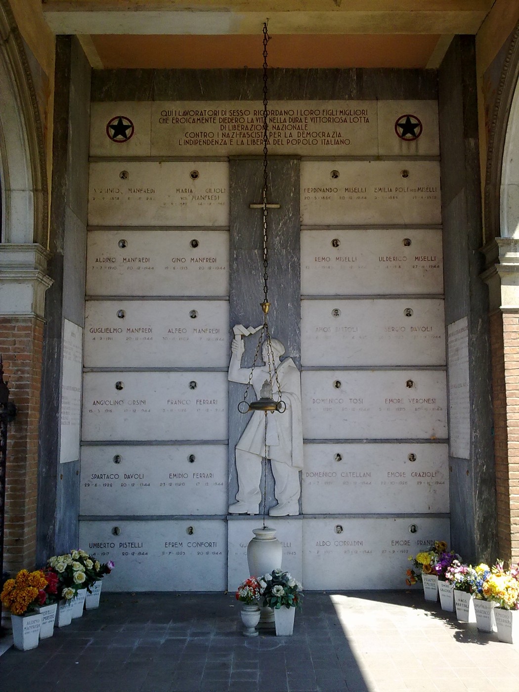 Sacrario dei Caduti di Sesso, luogo di memoria dedicato ai caduti con vasi di fiori e un'atmosfera di rispetto.