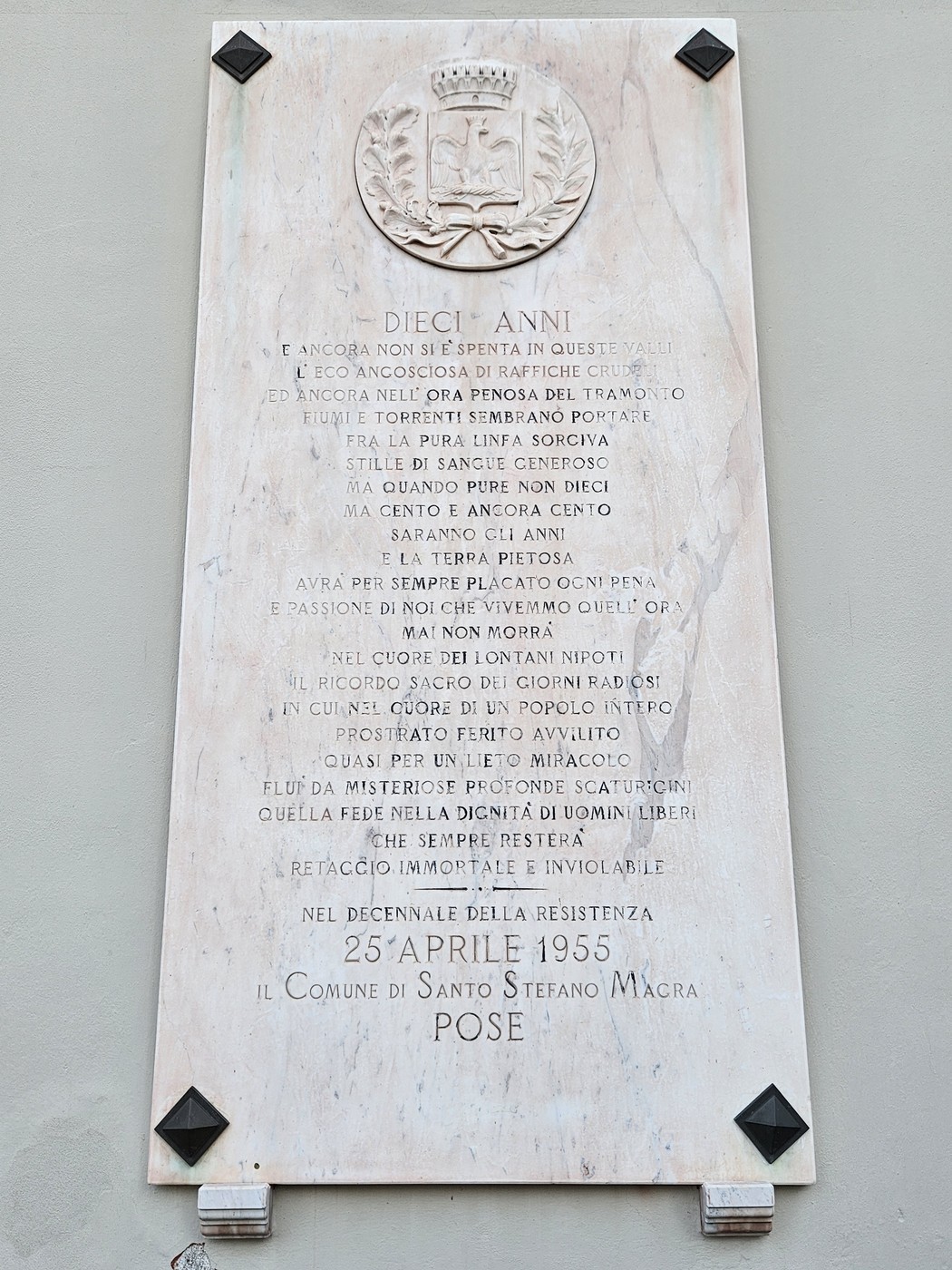 Lapide commemorativa del decennale, con decorazioni e simboli, situata a Santo Stefano Macra.