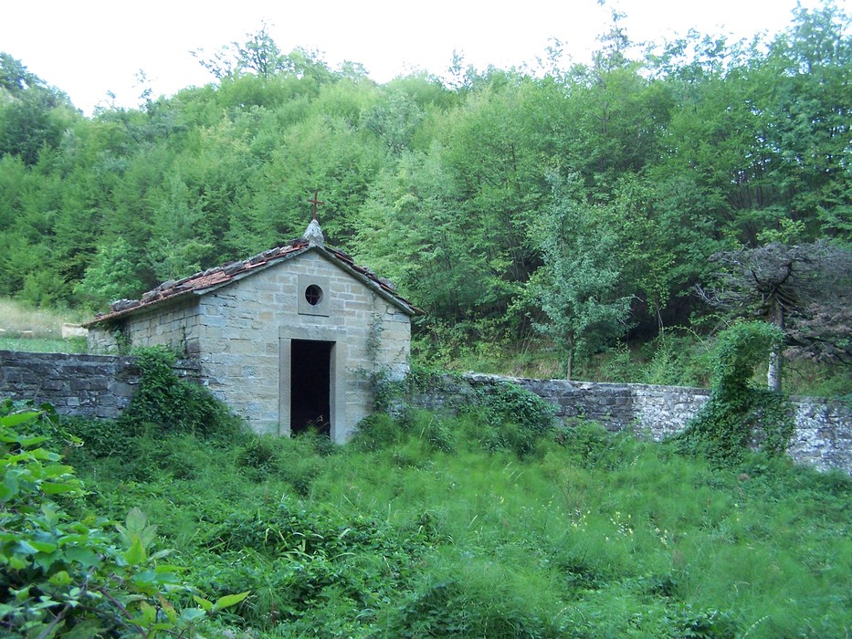 Monumento ai caduti Neri e Bellenghi, immerso nella natura, con un edificio in pietra e vegetazione circostante.