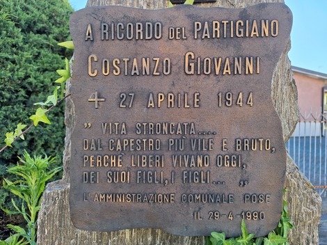 Cippo commemorativo dedicato al partigiano Costanzo Giovanni, con data e messaggio di ricordo.