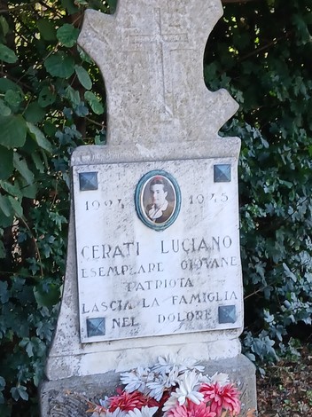 Cippo commemorativo dedicato a Luciano Cerati, giovane patriota, inserito in un contesto verde.