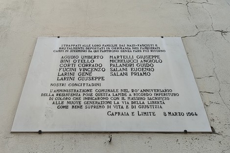 Lapide commemorativa dedicata ai deportati, con nomi di vittime e messaggio di memoria storica.