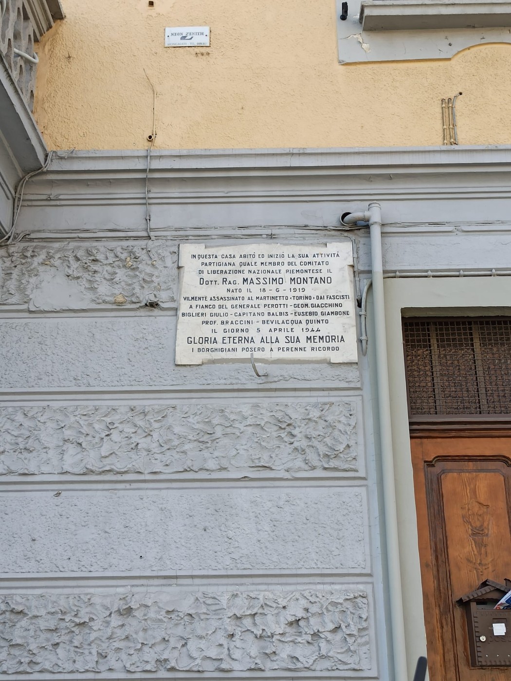 Lapide commemorativa dedicata a Massimo Montano, affissa su una parete con decorazioni.