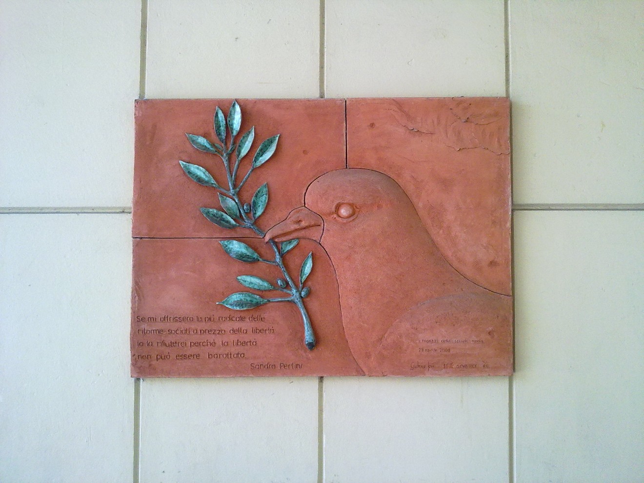 Lapide commemorativa dedicata alla Lotta di Liberazione, con simboli di pace e libertà.