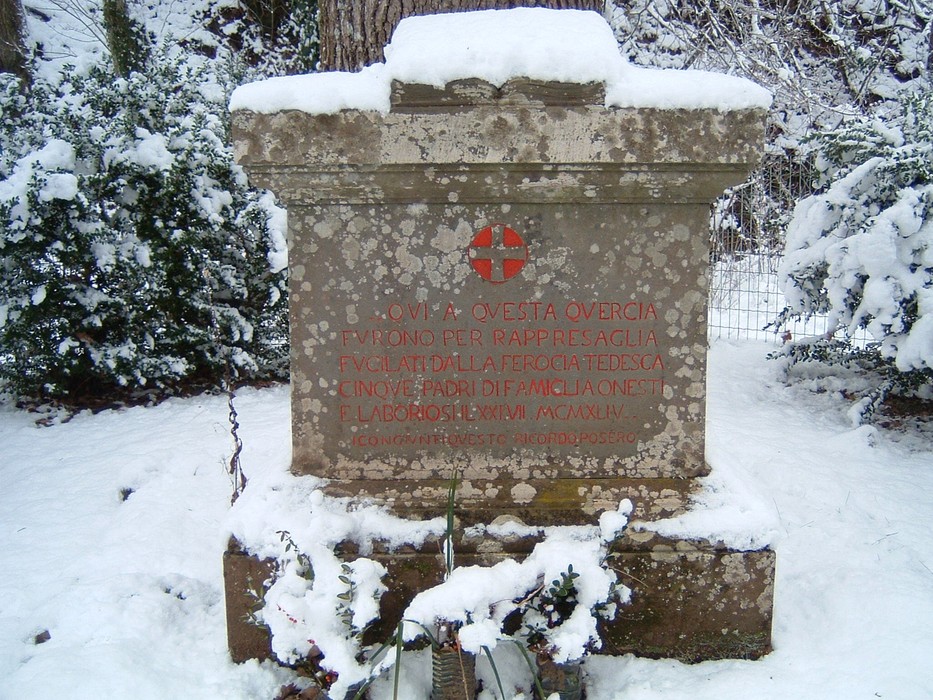 Cippo commemorativo ai caduti della Querce di Buonasera, immerso nella neve, simbolo di memoria e rispetto.