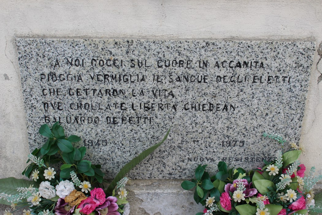 Sacrario dei partigiani con lapide commemorativa e fiori. Rappresenta il ricordo dei caduti per la libertà.