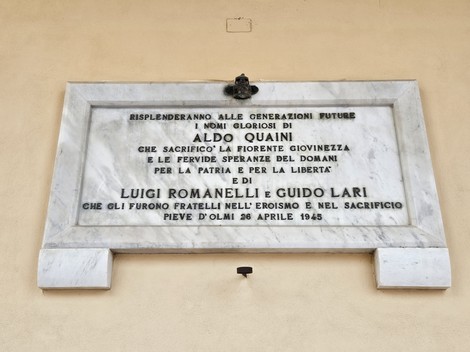 Lapide commemorativa dedicata ai caduti per la libertà, con nomi di eroi locali incisi.