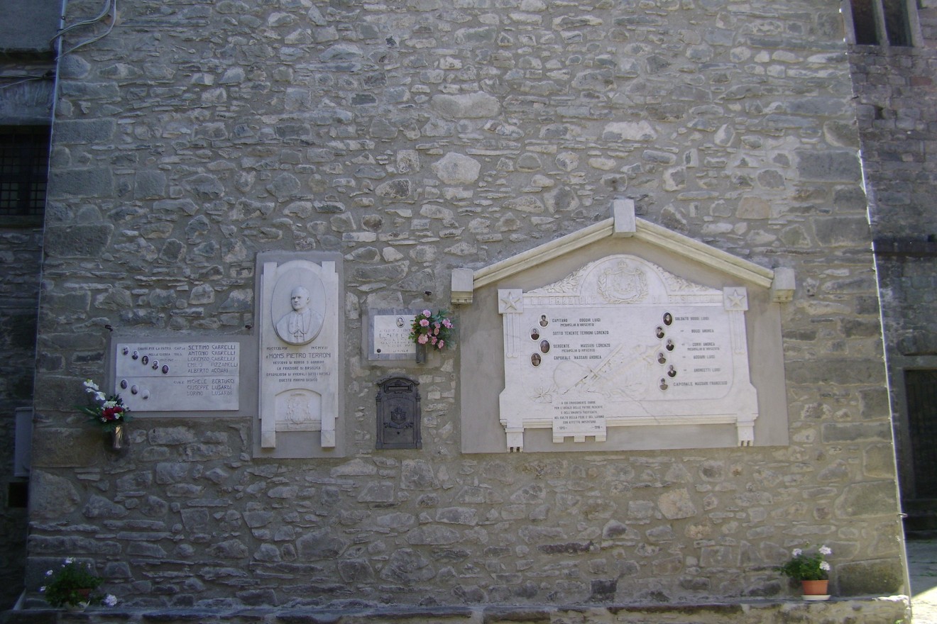 Lapide commemorativa dedicata ai caduti di Baselica, situata su una parete di pietra.