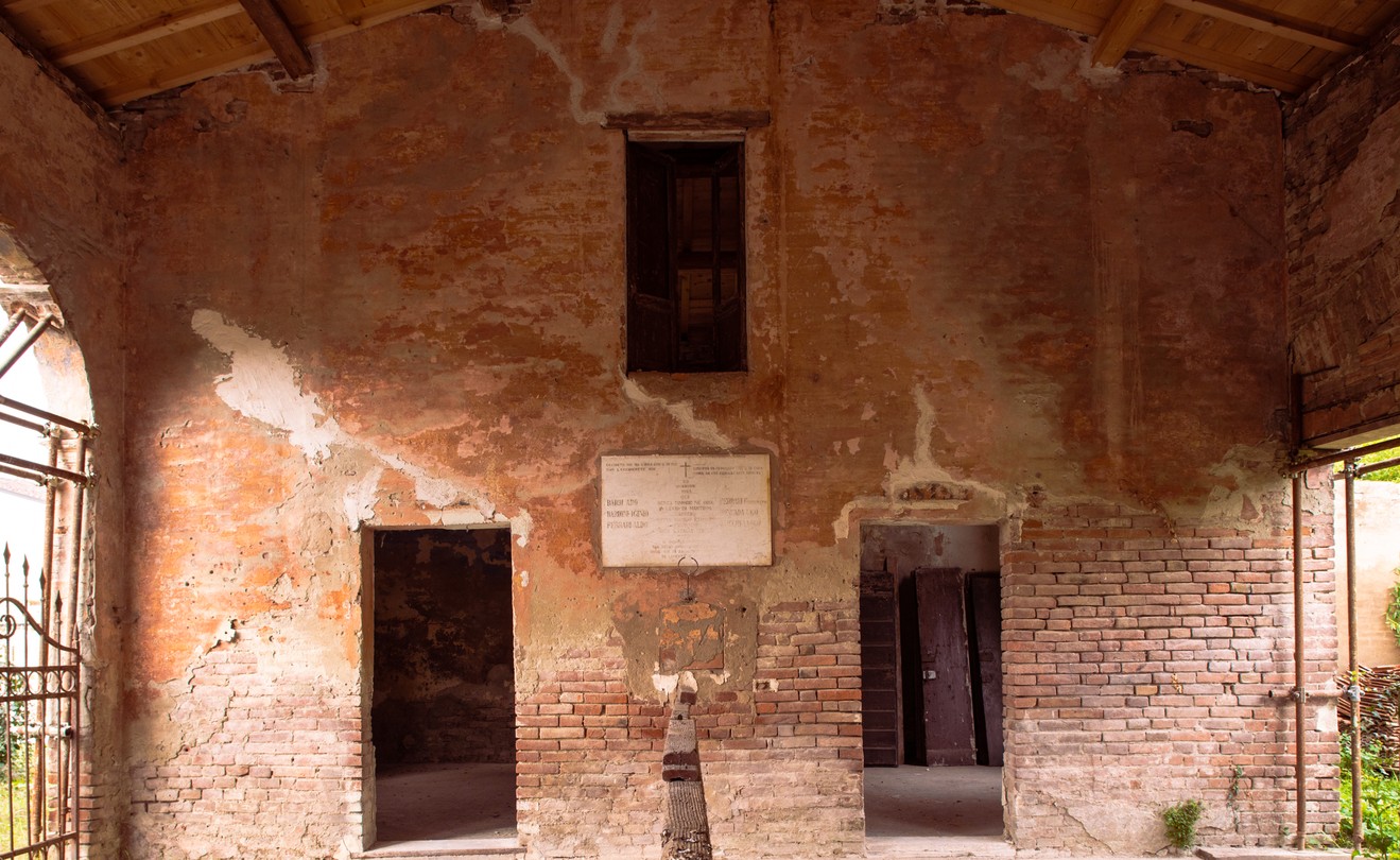 Interno del Poligono di tiro di Gonzaga, con pareti in mattoni e intonaco degradato. Atmosfera storica e suggestiva.