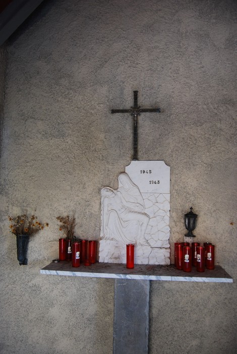 Sacrario di Tecchia: monumento commemorativo ai caduti della Linea Gotica, con candele e lapide.