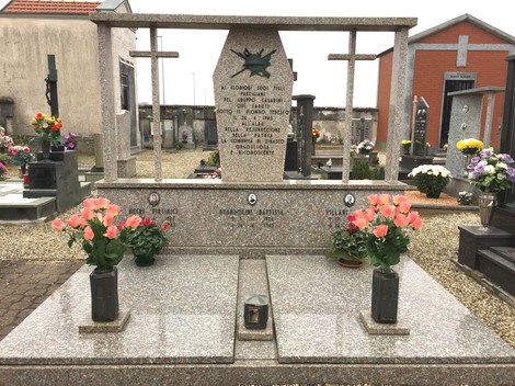 Monumento commemorativo dedicato ai caduti del gruppo Casarini, con fiori e croci nel cimitero.