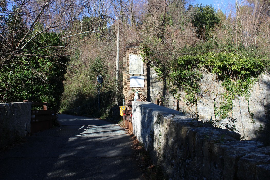 Lapide commemorativa ai partigiani fucilati, situata in un contesto naturale e storico al Forte Castellaccio.