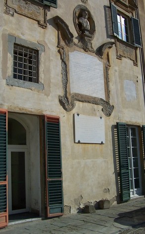 Lapide a Lorenzoni su una parete storica, con dettagli architettonici e finestre colorate.