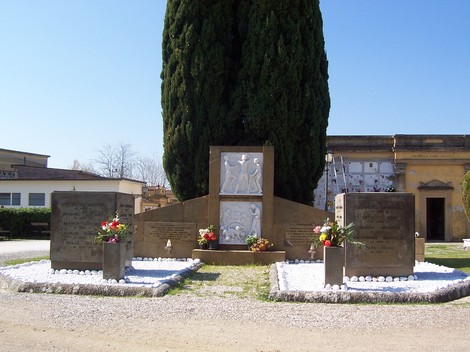 Monumento commemorativo dedicato ai bambini del collegino di Colonnata, con fiori e decorazioni.