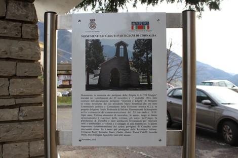 Cappella dedicata ai partigiani caduti, circondata da paesaggio montano e caratterizzata da un'atmosfera di memoria e riverenza.