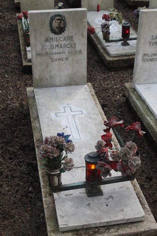 Tombe con croci, fiori e lumini commemorativi per i caduti per la Libertà, in un cimitero.