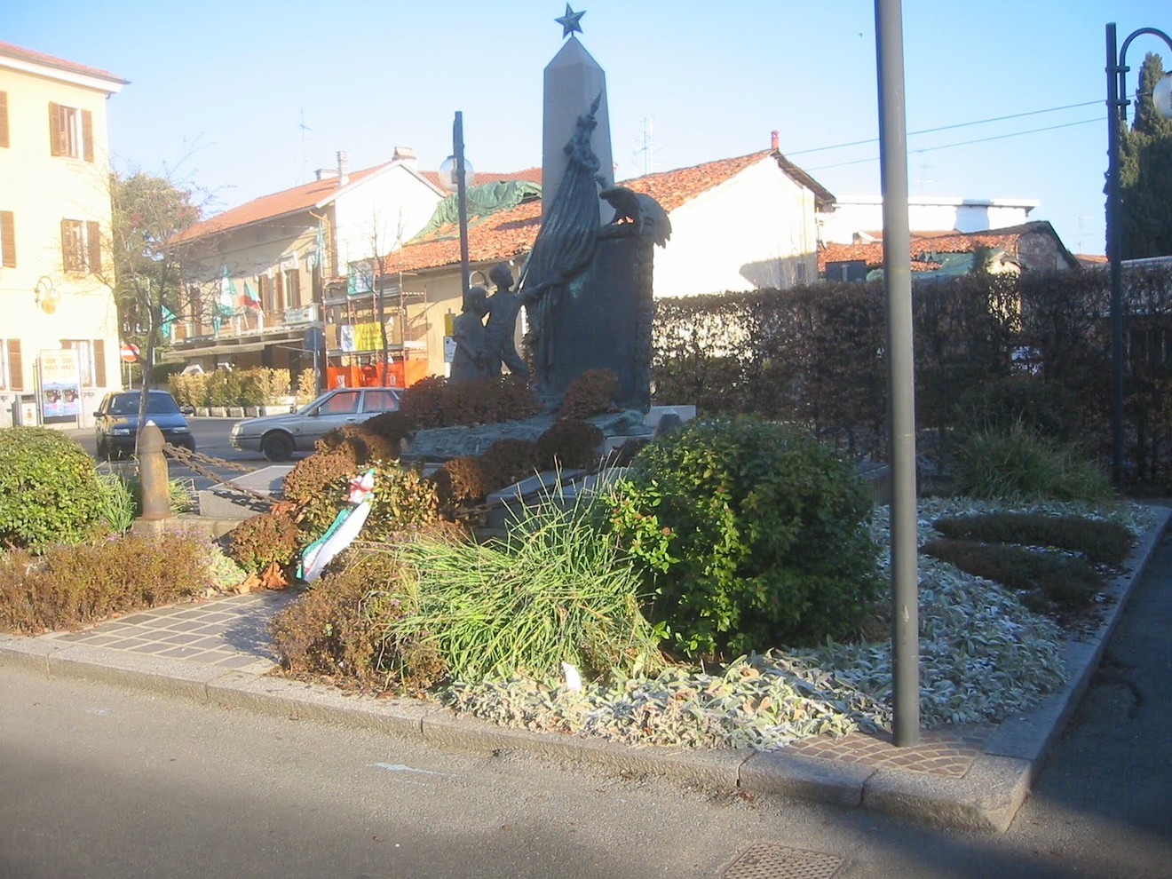 Monumento ai caduti circondato da verde, commemorativo e situato in un'area urbana.