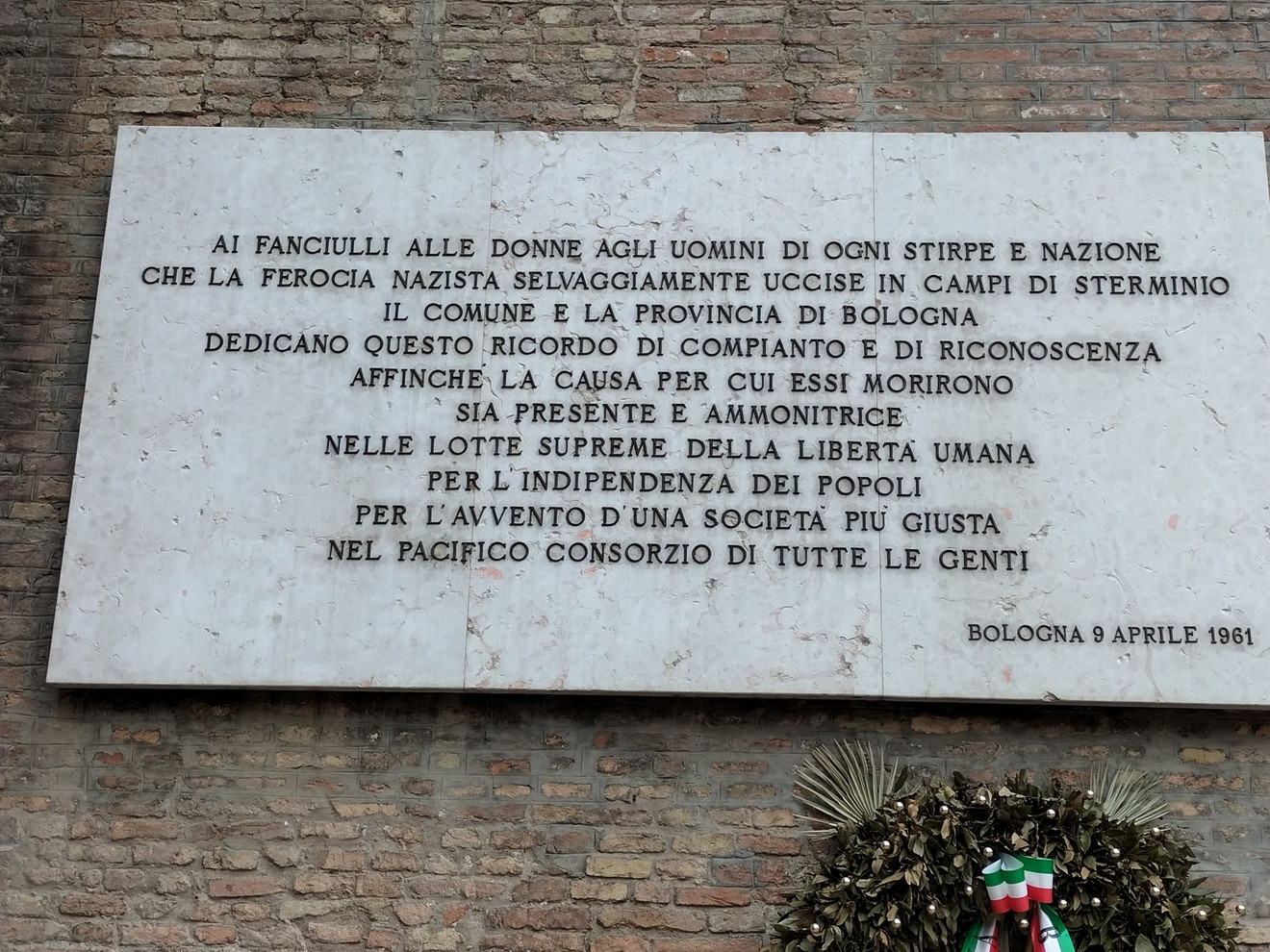 Lapide commemorativa delle vittime nei campi di sterminio, Bologna, 1961. Riflessione sulla libertà e l'umanità.