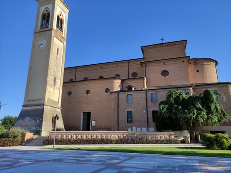 Monumento commemorativo degli eventi tragici di Santa Giustina in Colle, con vista sulla chiesa e il campanile.