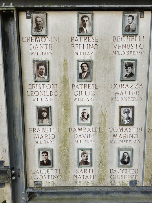 Lapidi commemorative con foto di caduti della seconda guerra mondiale e nomi incisi in memoria dei militari.