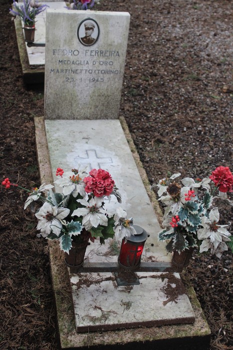 Tombe perpetue dei caduti per la Libertà con decorazioni floreali e lumino commemorativo.