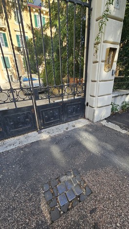 Pietre d'inciampo dedicate alla famiglia Coen - Finzi posizionate davanti a un cancello.