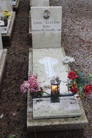 Tombe commemorate con croci e fiori, dedicate ai caduti per la Libertà, in un ambiente di rispetto e memoria.