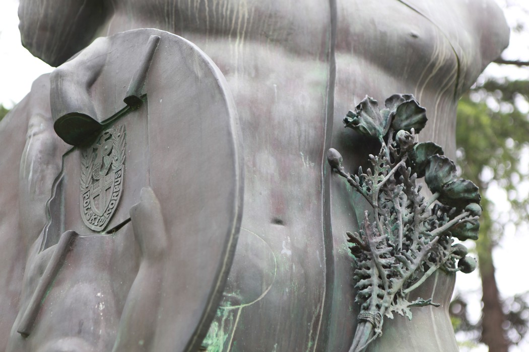 Dettaglio del Monumento ad Anders, con una figura umana e elementi floreali in bronzo.