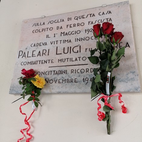 Lapide commemorativa di Paleari Luigi, vittima del fascismo, decorata con fiori.