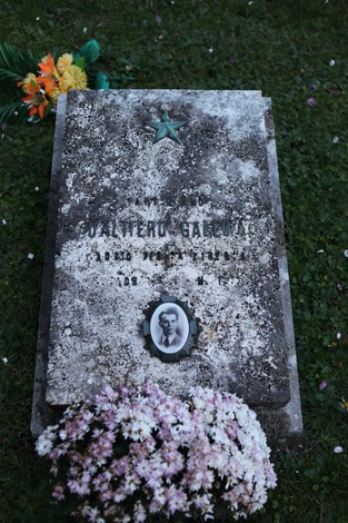 Tomba commemorativa dei partigiani pratesi, con fiori e foto in onore dei caduti.