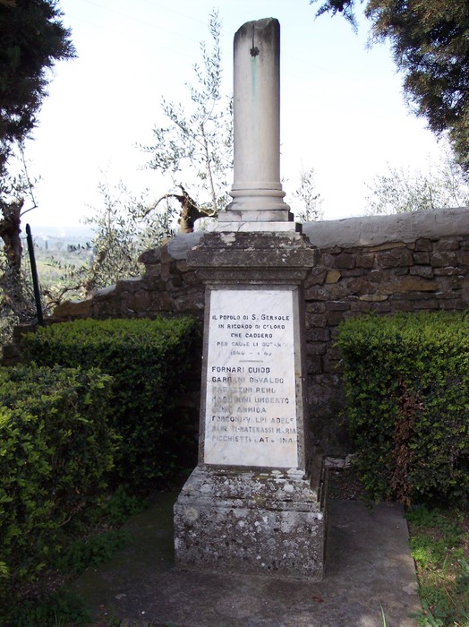 Cippo commemorativo ai caduti di San Gersolé, circondato da vegetazione e panorami collinari.