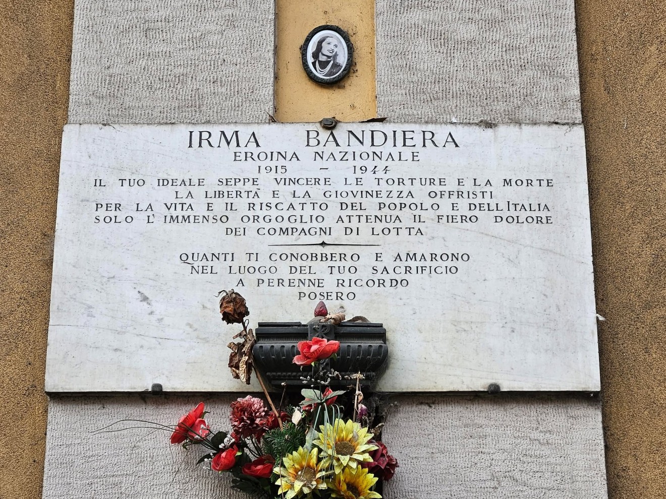 Lapide commemorativa di Irma Bandiera, eroina nazionale, con fiori e dedica al sacrificio e alla lotta per la libertà.