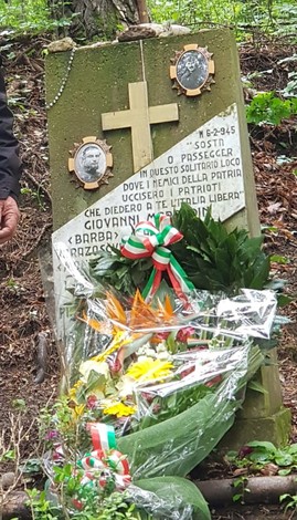Cippo commemorativo con fotografie e omaggio floreale nel bosco, in ricordo di Giovanni Morandin e Vorazoscvilj.