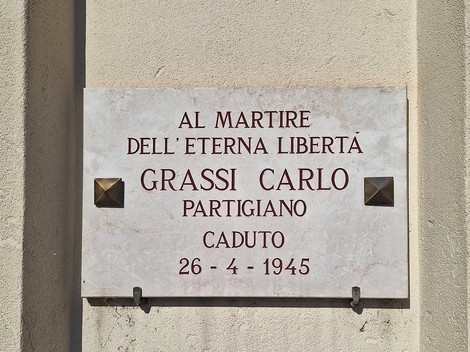 Lapide commemorativa dedicata a Carlo Grassi, partigiano caduto nel 1945, in memoria della libertà.