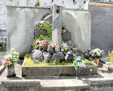 Monumento commemorativo dedicato ai martiri della Libertà a Mongrando, adornato di fiori e rocce.