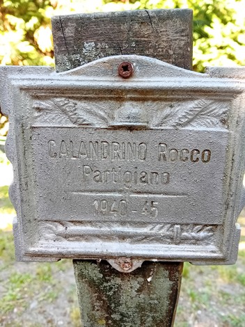 Targa commemorativa di Rocco Calandrino, partigiano, al Parco della Rimembranza, con decorazioni rurali.