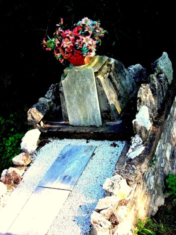 Cippo a Fiore con decorazioni floreali, situato in un contesto naturale, simbolo di ricordo e omaggio.