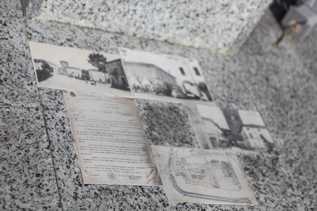 Monumento alle vittime del bombardamento, con foto storiche e documenti storici collocati su una superficie.